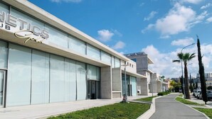 A modern building with a sign reading "METICS Gold". - Luxury 2BR Apt at Elysia Park S6 with Pools, Gym & Spa - Center Paphos (Pafos)