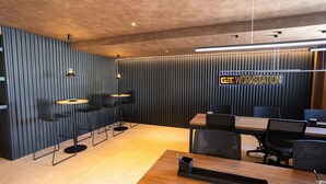 A modern conference room with a wooden table, black chairs, and a 'GET WORKSTATION' sign. - Get By Side #702 - Modern Studio by Carpediem (João Pessoa)