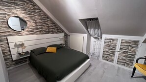 Una camera da letto con un letto, un comodino, uno specchio, un termosifone e un armadio.
