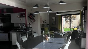 Una cucina moderna con zona pranzo, ampie finestre e vista sull'esterno.