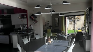 Et moderne køkken med spiseplads, store vinduer og udsigt til det fri.