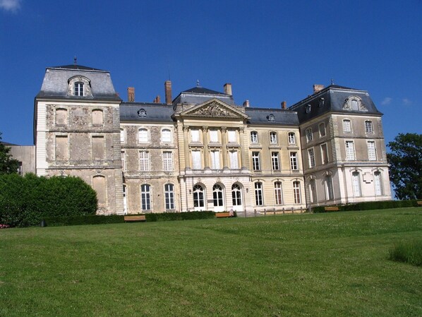 A large, historic building with multiple stories, a central entrance with columns, and a symmetrical facade.