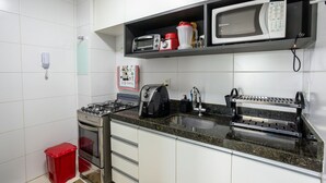 A kitchen with a gas stove, oven, microwave, toaster, and a sink. - Buenos Ayres #504 - Comfortable Apartment by Carpediem (João Pessoa)