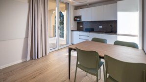 A modern kitchen with a built-in microwave, a dark countertop, and white cabinets. - Villa Pignone 12 (Genova)