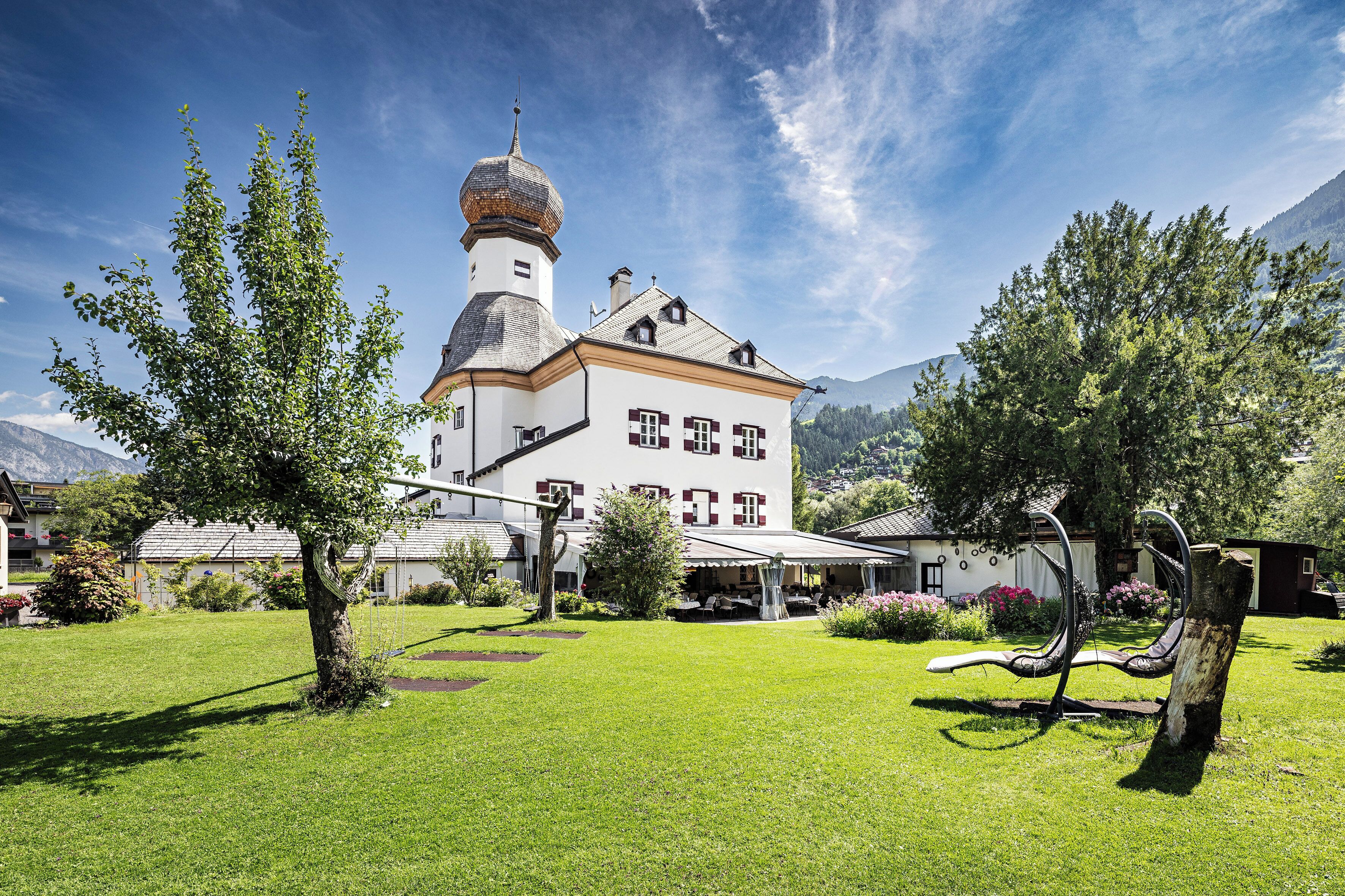 A large building with a prominent tower, surrounded by a well-maintained lawn and trees.