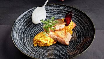 A plate with salmon, mashed potatoes, and a garnish.
