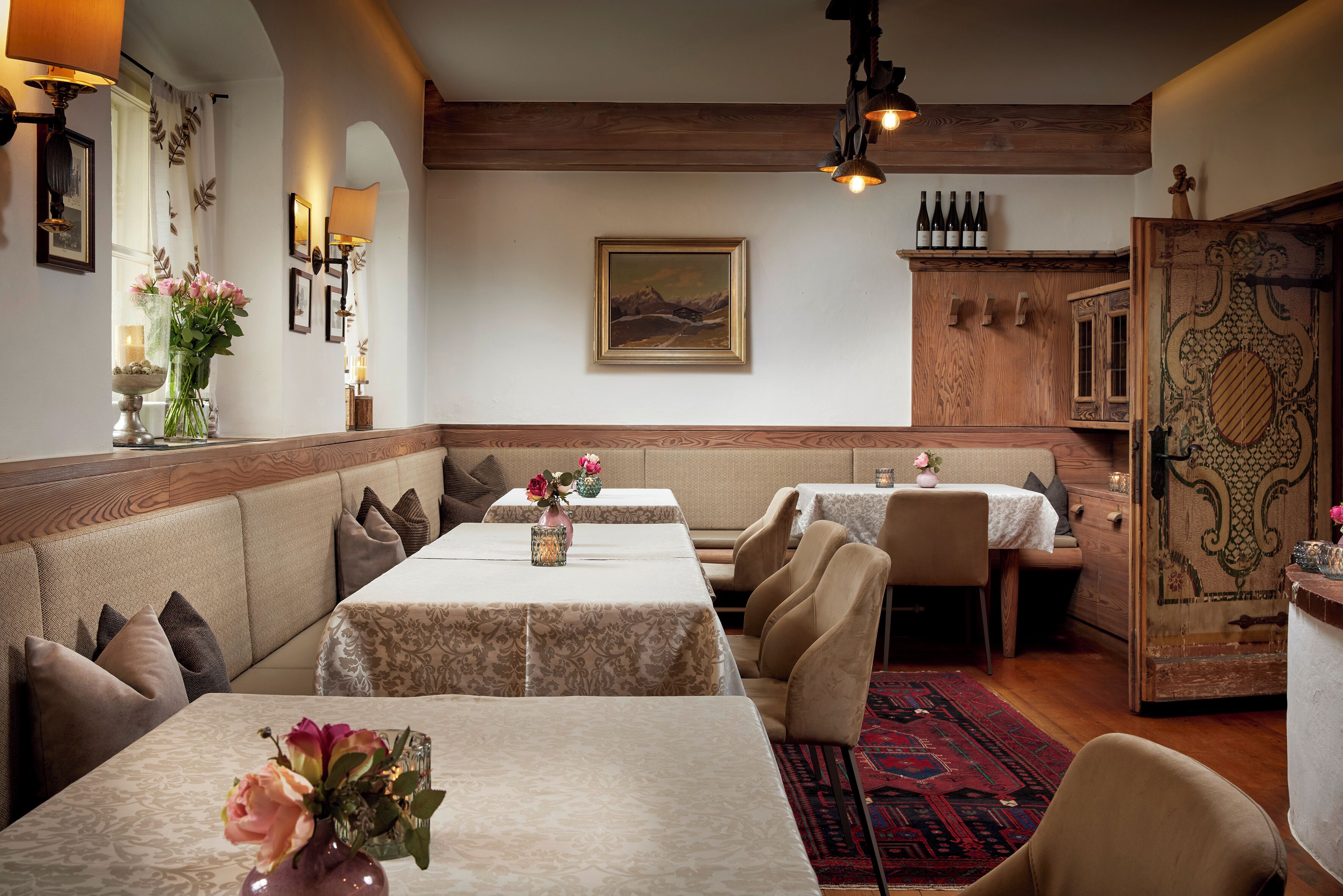 Un restaurante con mesas largas, asientos acolchados y una decoración de madera.
