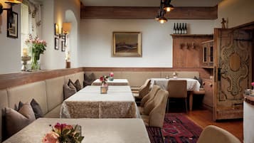 Un restaurante con mesas largas, asientos acolchados y una decoración de madera.
