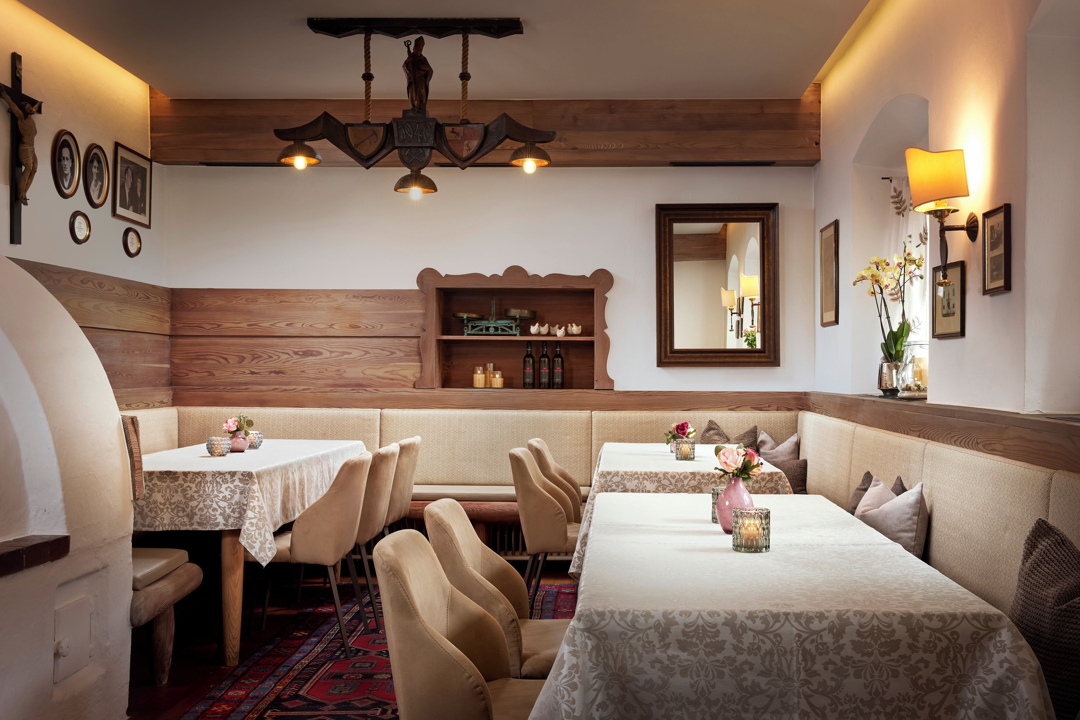 A dining area with wooden paneling, a chandelier, and a mirror on the wall.