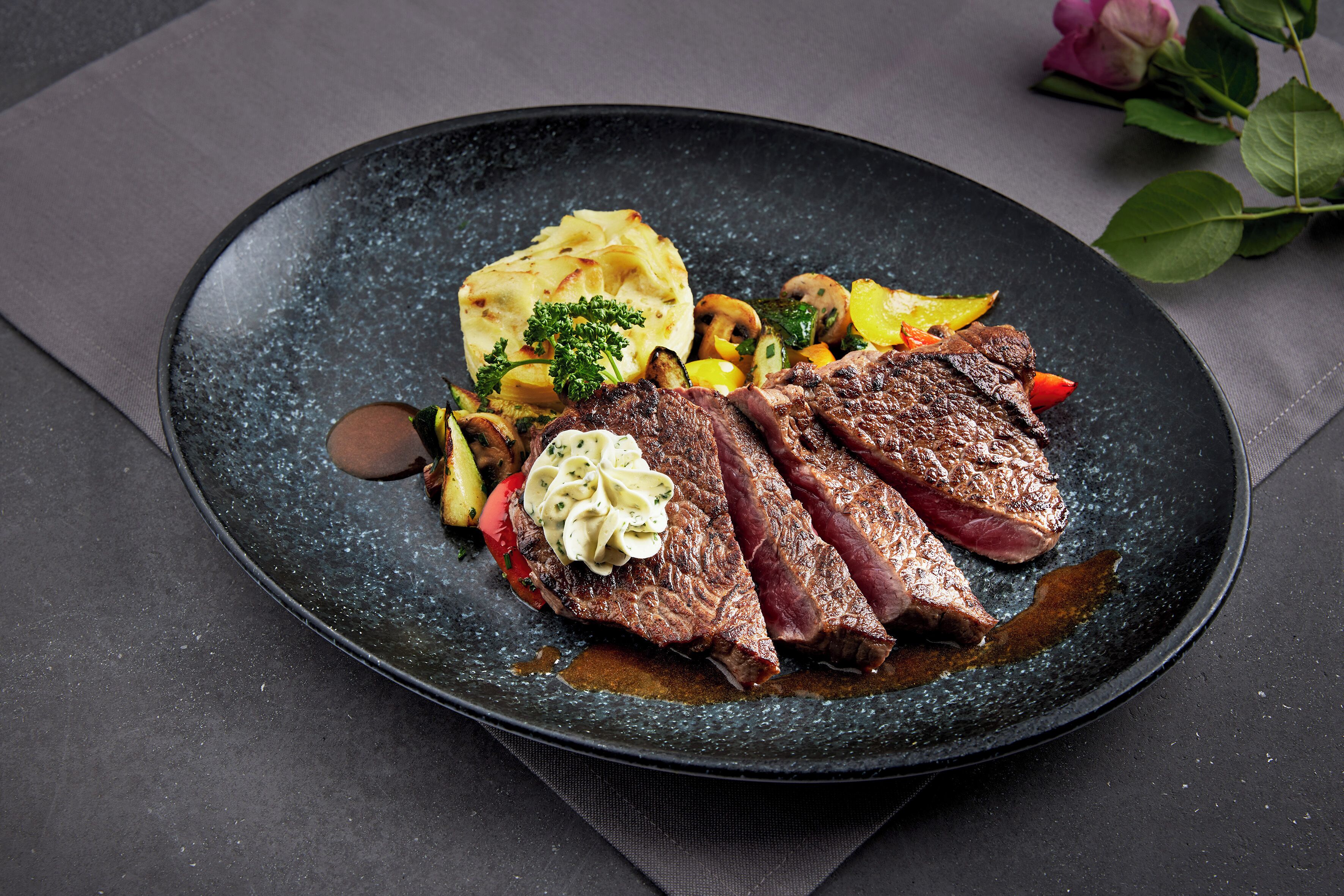 A plate of food with steak, vegetables, and mashed potatoes.