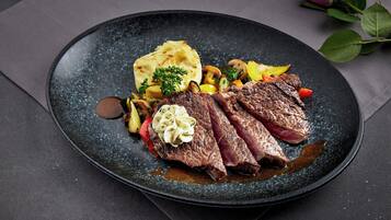 A plate of food with steak, vegetables, and mashed potatoes.