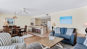 Ett kompakt bostadsutrymme med en matplats, ett litet kök och en soffgrupp.