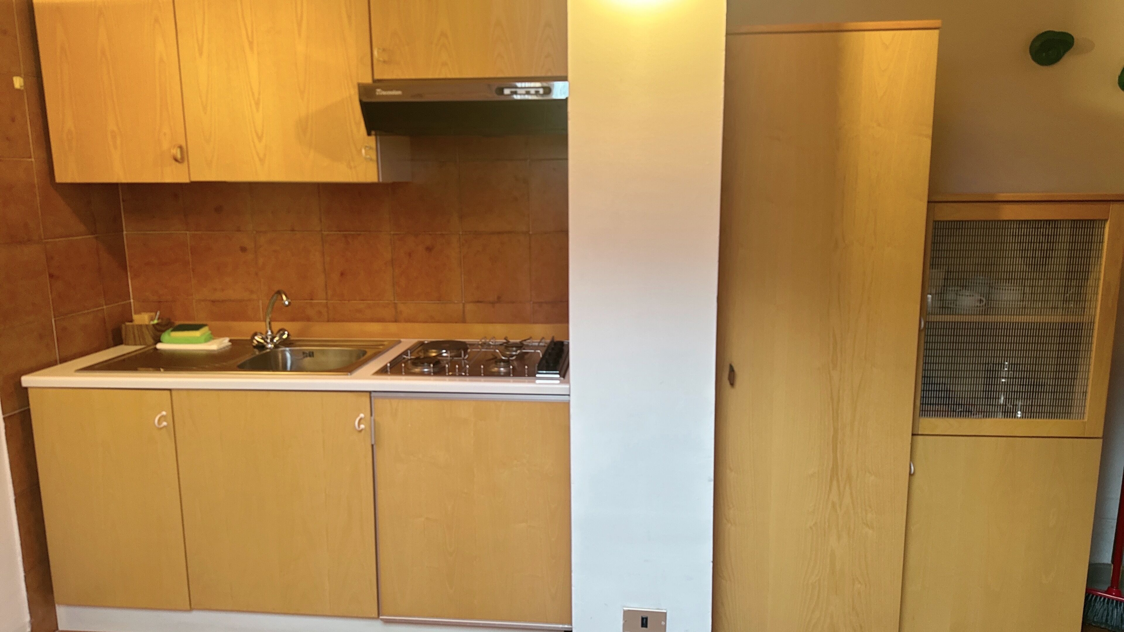 A kitchen with wooden cabinets, a stainless steel sink, and a gas stove.
