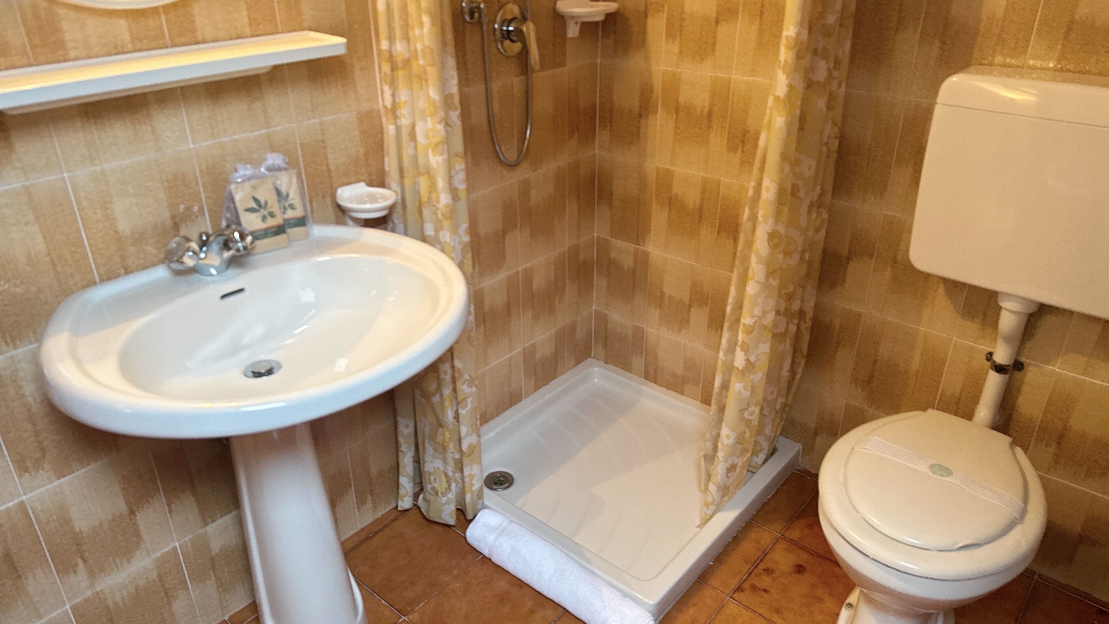 Ein Badezimmer mit Waschbecken, Dusche und Toilette.