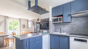 Eine moderne Küche mit blauen Schränken, einem Geschirrspüler und einem eingebauten Backofen.