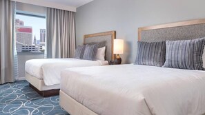 A hotel room with two beds, a city view, a large window with curtains, and a patterned carpet. - No resort fees- 2 bdrm (Las Vegas)