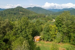 A large, isolated building surrounded by dense forest and mountains. - 100 Acre Reserve | River Access, Endless Adventure (Cullowhee)