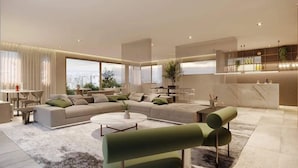 Una sala moderna con un sofá modular, una mesa de centro redonda y un sillón verde.