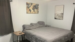 A bedroom with a bed, a small table, and two artworks on the walls. - PERFECT MIAMI STAY 4-bedroom 2 bath with luxury shower in O (Oxford)