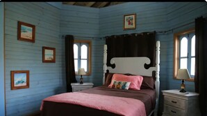 Un dormitorio con una cama de madera, dos mesitas de noche y una ventana con cortinas.