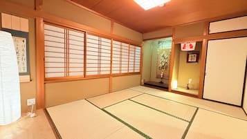 A traditional Japanese room with tatami flooring, sliding doors, and a shoji screen.