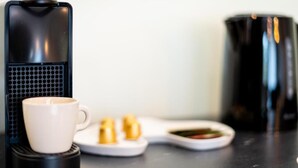 A coffee maker, a white mug, and a plate with condiments on a kitchen counter. - Malila Apartments Cracow Grzegórzecka 15 (Kraków)
