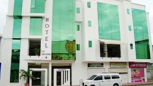 A hotel with a modern facade, a visible restaurant entrance, and a parked van in front. - Hotel La Sultana  (Tumaco)