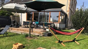 A backyard with a hammock, a wooden board game, and outdoor furniture. - Large family home in the heart of Redon near the train station (Redon)