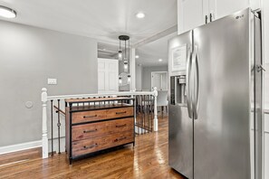 Eine Küche mit einem Edelstahlkühlschrank, Holoszillen und einer weißen Arbeitsplatte.
