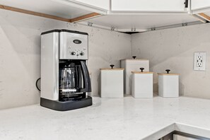 A kitchen with a coffee maker, cabinets, and a countertop. - Evergreen Acres • Woodland Preserve • Private Pool (South Haven)