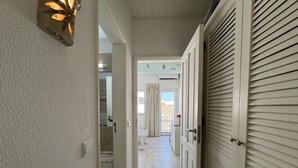 A hallway with a light fixture, a door with a window, and a view of the outside. - Cabanas DE Tavira Charming by Homing (Tavira)