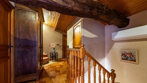 A wooden staircase with a handrail, a wooden door, and a tiled floor.