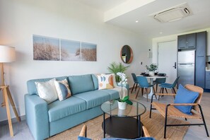 Ein modernes Wohnzimmer mit einer Couch, einem Couchtisch und einem Essbereich mit Stühlen.
