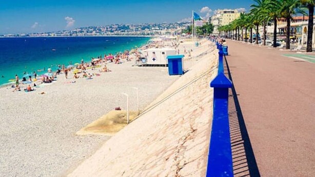 A beach with a blue railing, clear blue water, and a cityscape in the background. - Apartment "Accommodation for 4 People" with Private Terrace and Wi-Fi (Nice)