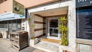 A building with a marble facade, a wooden bench outside, and a signboard. - Apartment "Accommodation for 4 People" with Private Terrace and Wi-Fi (Nice)