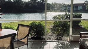 Un pati amb vistes a un llac, una taula i cadires.