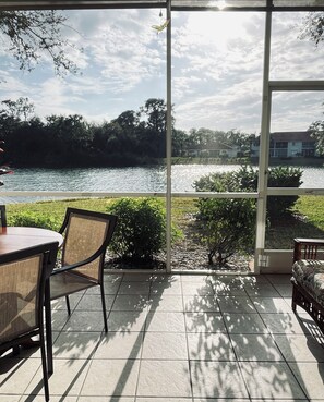 Eine Terrasse mit Seeblick, einem Tisch und Stühlen.