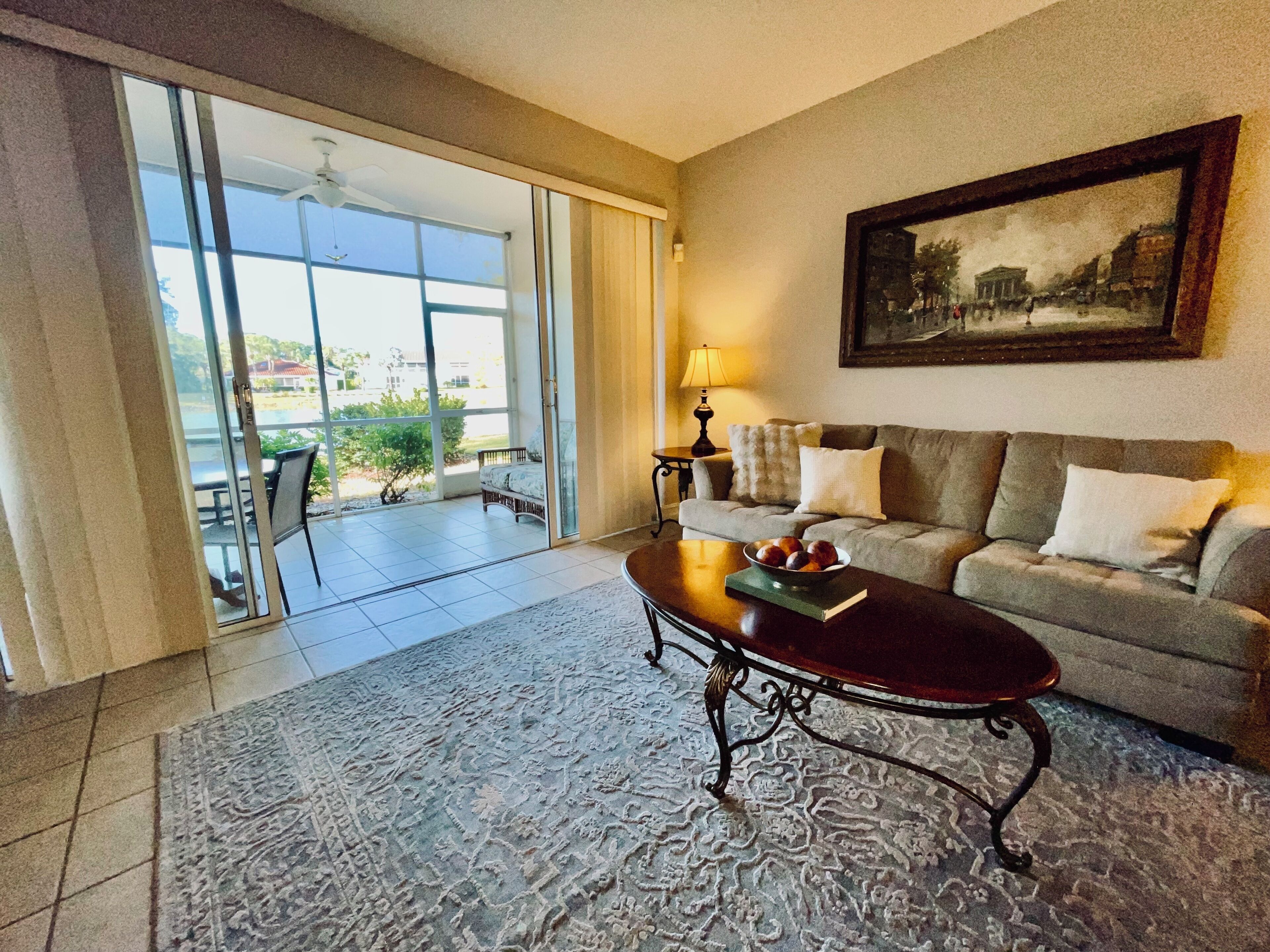 A living room with a sofa, coffee table, and a painting on the wall.