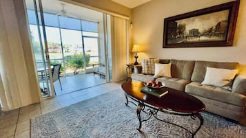 A living room with a sofa, coffee table, and a painting on the wall.