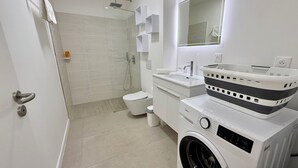 A modern bathroom with a shower, toilet, sink, and washing machine. - Studio Vairagi City, brand new in the center of Papeete, WiFi -Netflix -A/C (Papeete)