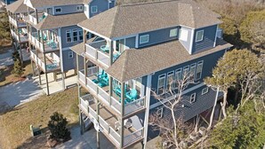 A multi-story residential building with a balcony, a view of the water, and a clear sky. - Decks with Ocean Views, Grill, 2 King Suites, Dogs Welcome, 2 Min Walk to Beach (Surf City)