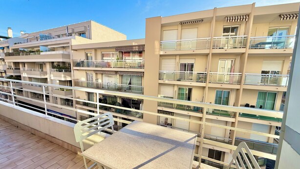 A multi-story residential building with balconies, a covered outdoor seating area, and a view of the surrounding neighborhood. - Antibes City Center – 4 Guests (Antibes)