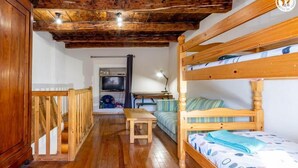 A wooden-floored room with bunk beds, a small table, and a television. - LE LEROT - JARSY - Gîte (JARSY)