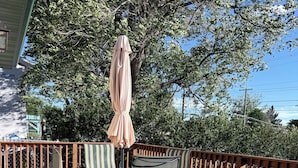 A wooden deck with a table and chairs, surrounded by a wooden fence.