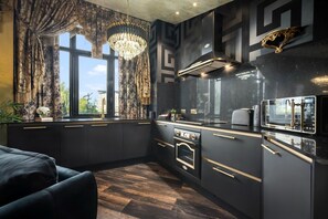 A modern kitchen with dark cabinetry, a built-in oven, and a microwave. - Opulent Penthouse - City Centre - 2Bedrooms - Balconies - 2Secure Parking Spaces (West Midlands)