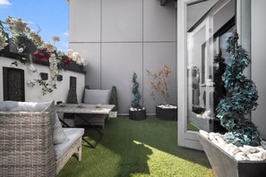 A patio area with a table and chairs, surrounded by potted plants and a small garden. - Opulent Penthouse - City Centre - 2Bedrooms - Balconies - 2Secure Parking Spaces (West Midlands)
