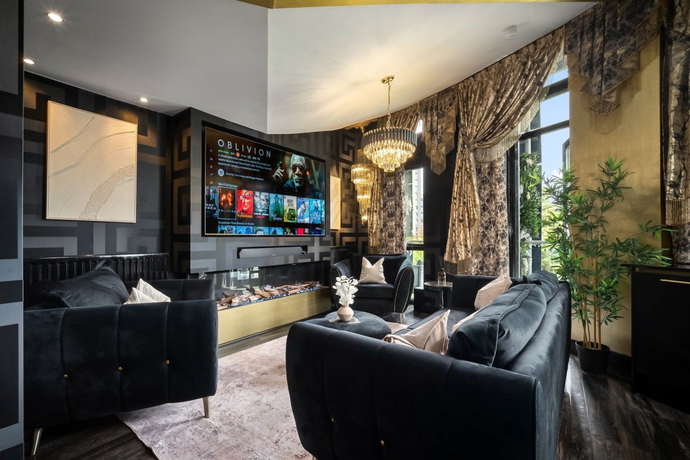 Ein modernes Wohnzimmer mit einem großen Flachbildfernseher, dunklen Sofas, einer dekorativen Vase und einem großen Fenster mit Vorhängen.