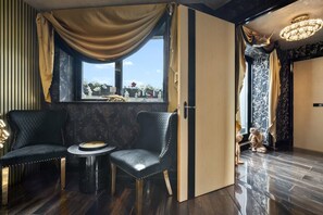A room with two black leather armchairs, a small round table, a large window with curtains, and a chandelier. - Opulent Penthouse - City Centre - 2Bedrooms - Balconies - 2Secure Parking Spaces (West Midlands)