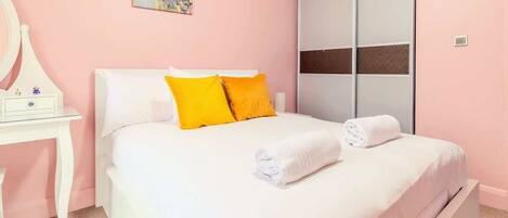A bedroom with a bed, a nightstand, a mirror, and a sliding door.