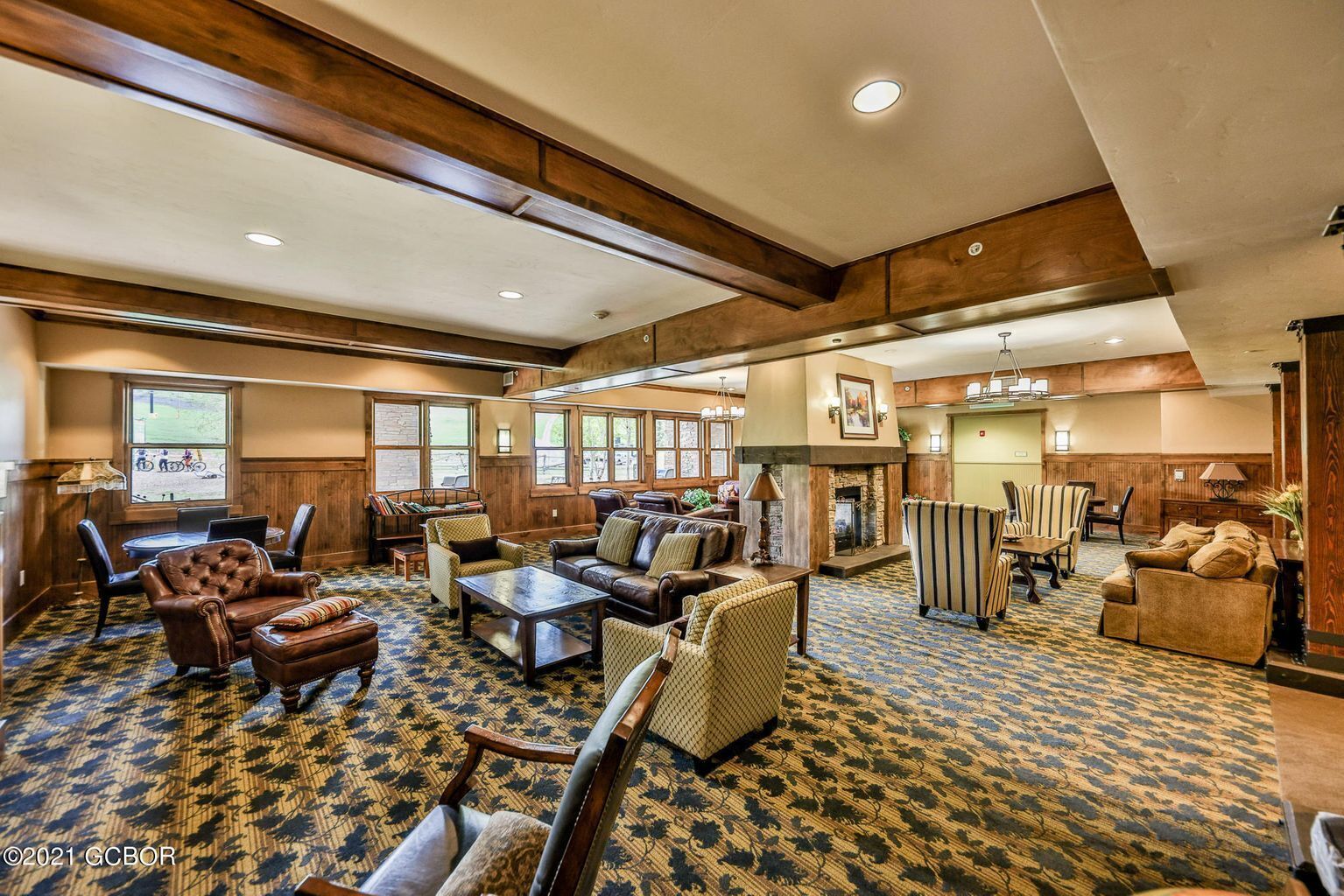 A spacious lobby with a fireplace, leather seating, and a patterned carpet.